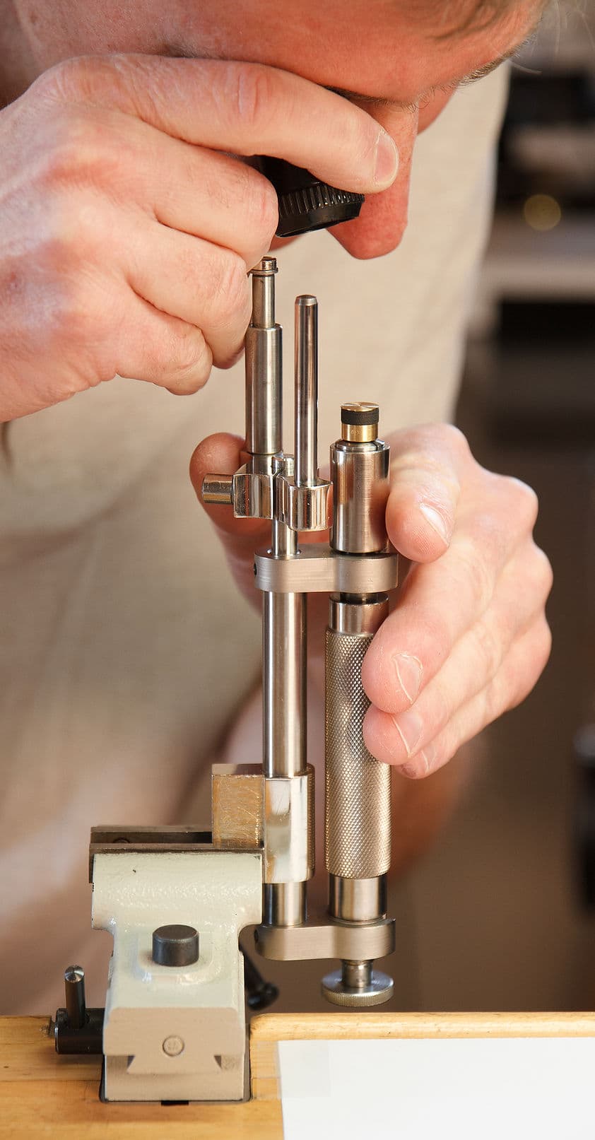 Watchmaker inspecting a component at the bench